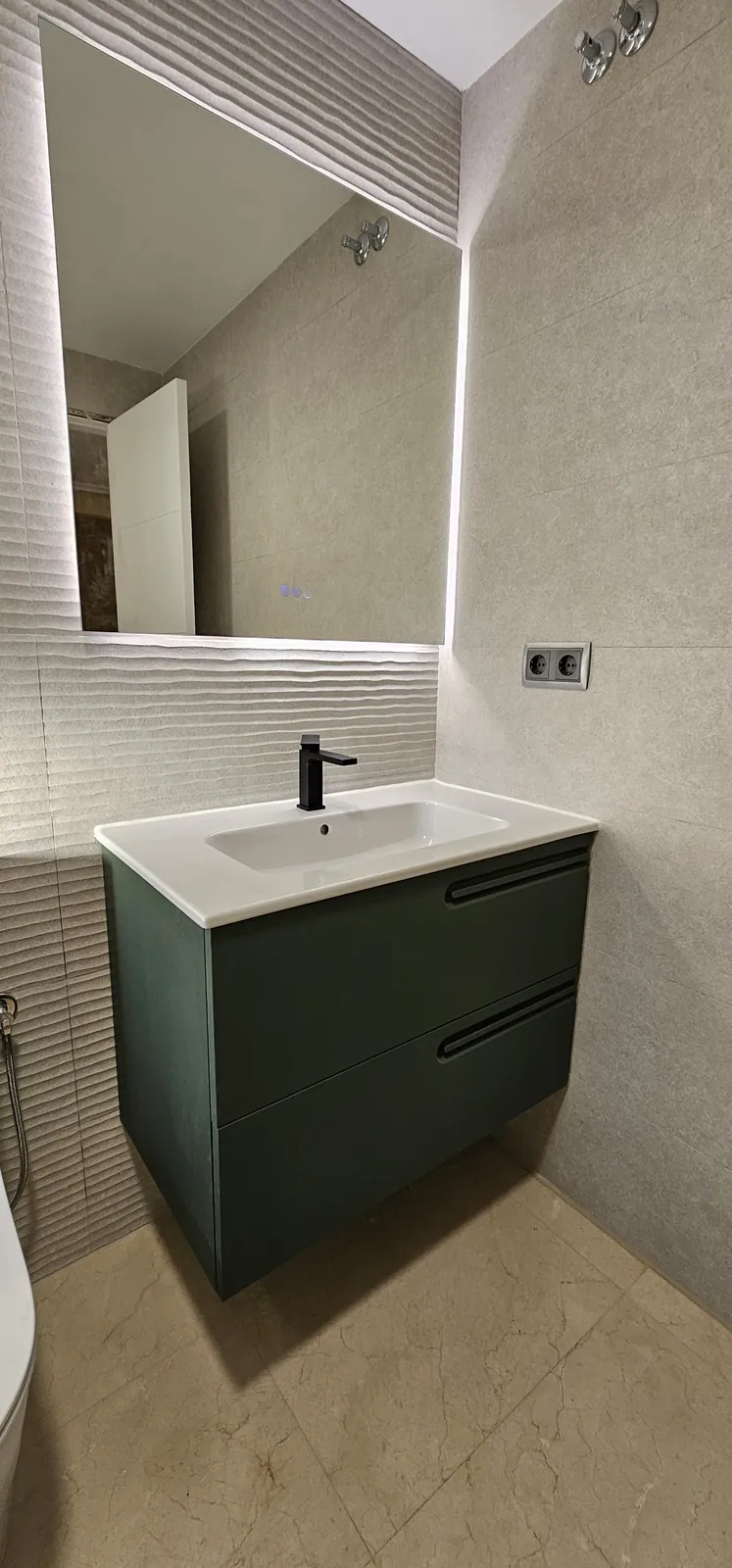 Lavabo con mueble verde y espejo con retroiluminación LED