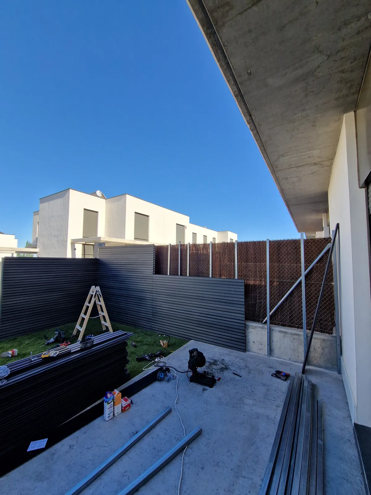 Patio durante la instalación de la valla de lamas y el pavimento