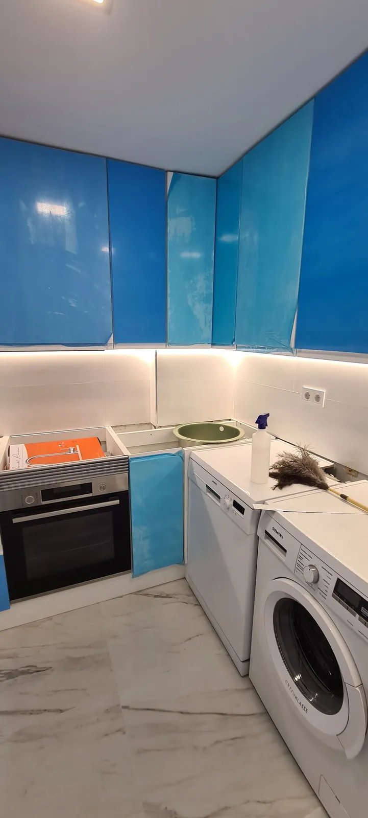 Cocina recién montada con los frentes aún protegidos con film azul