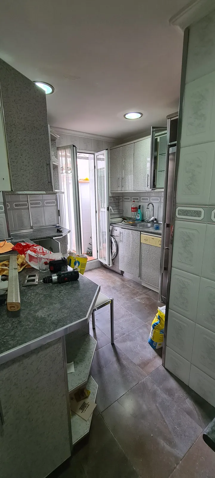 Cocina antes de la reforma con muebles antiguos y encimera oscura