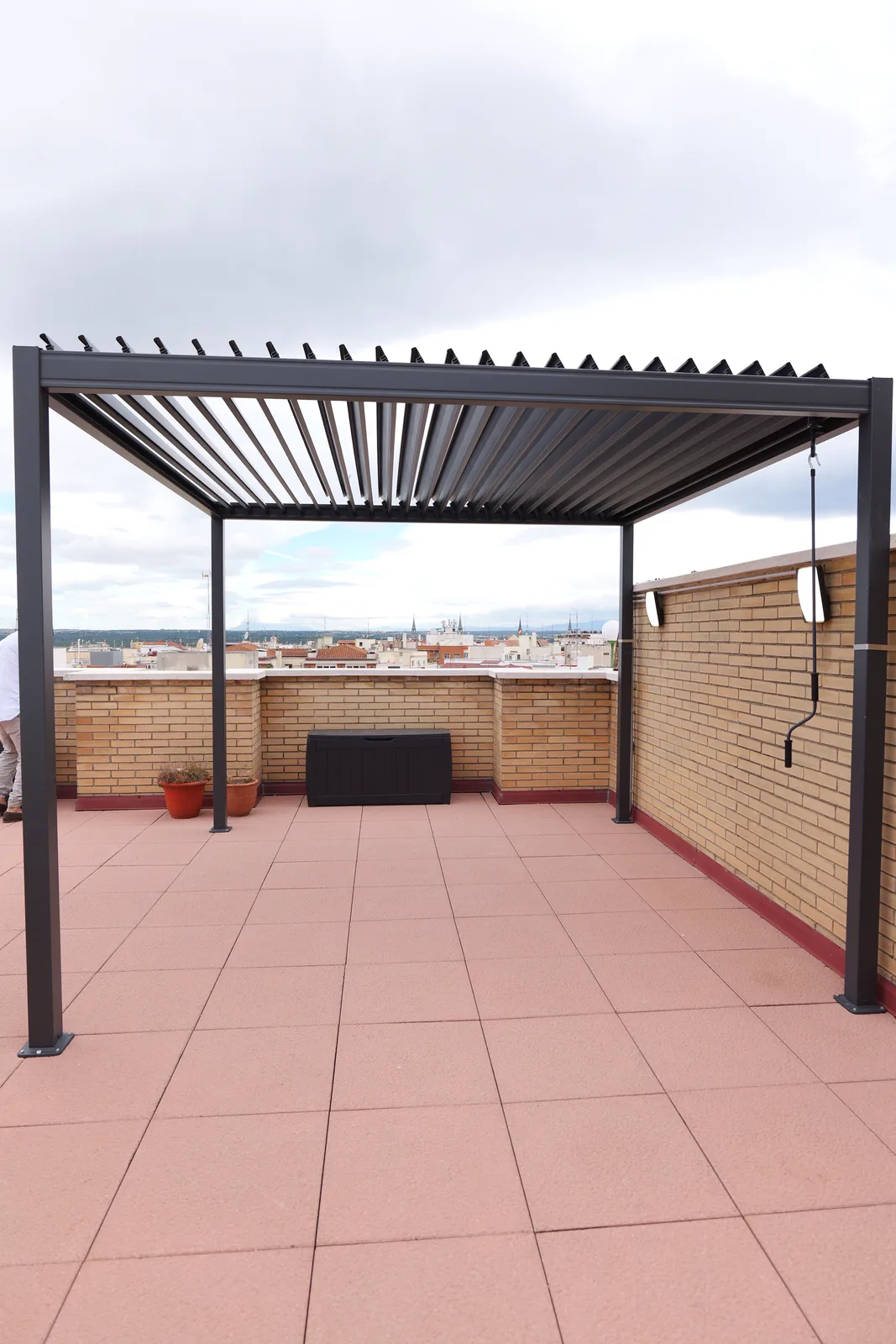 Terraza en cubierta con pérgola bioclimática de lamas en gris antracita y pavimento cerámico