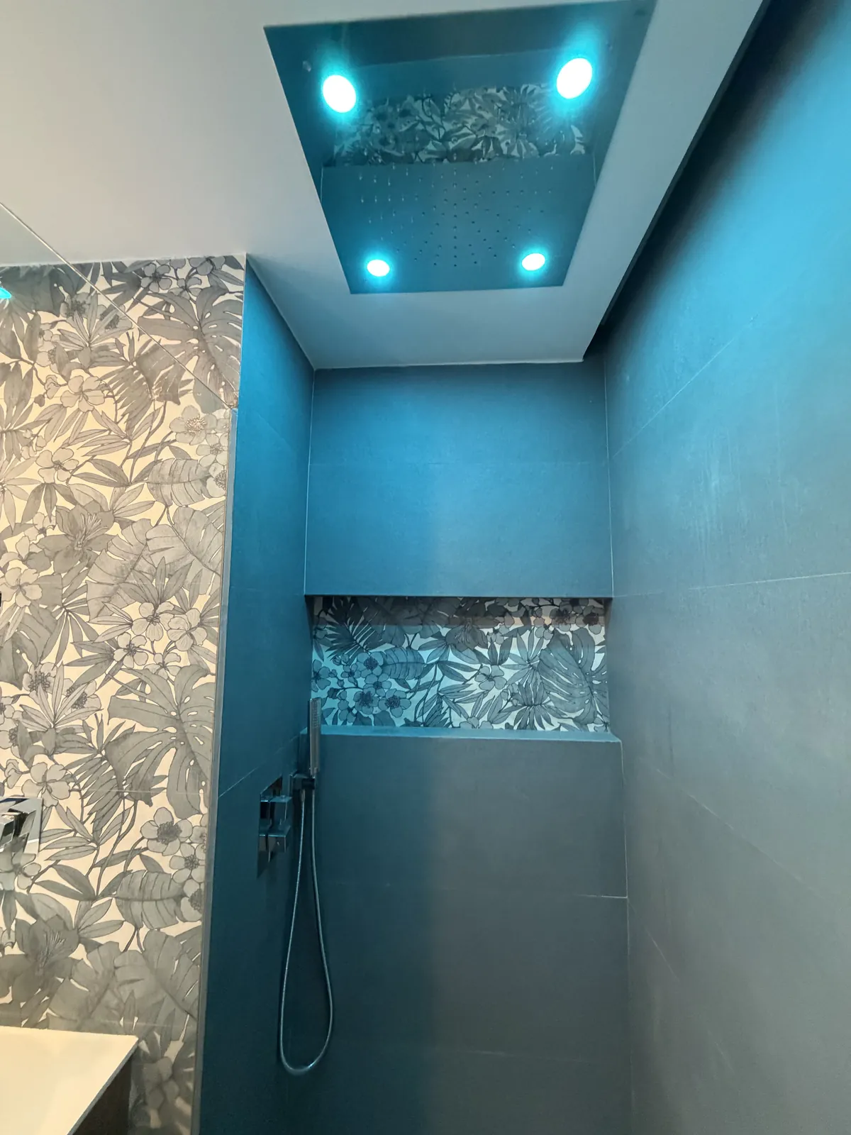 Ducha de obra con nicho decorado, rociador de techo e iluminación integrada