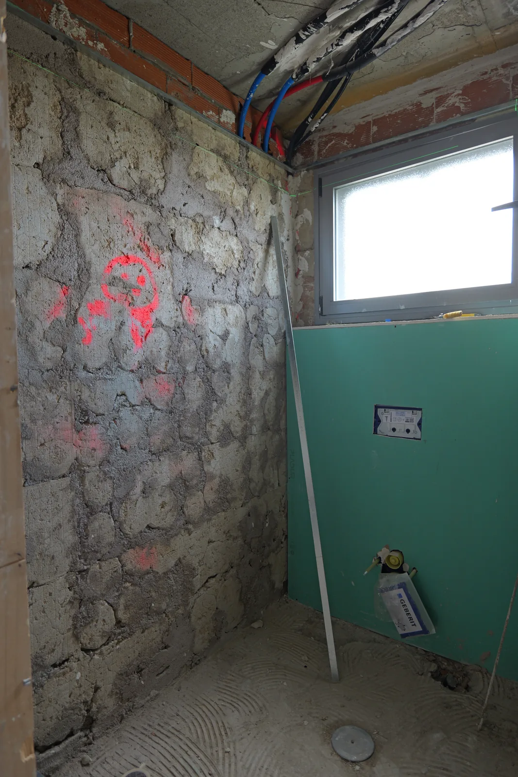 Baño en obra con placa hidrófuga y cisterna empotrada preparadas para el inodoro suspendido