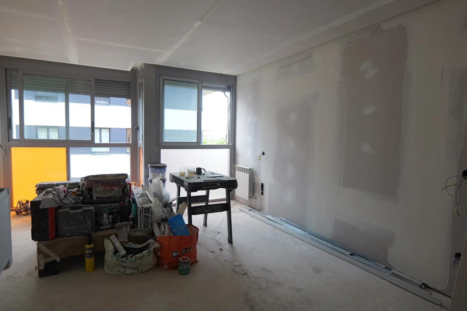 Salón durante la obra con techos y paredes de placa de yeso recién emplastecidos