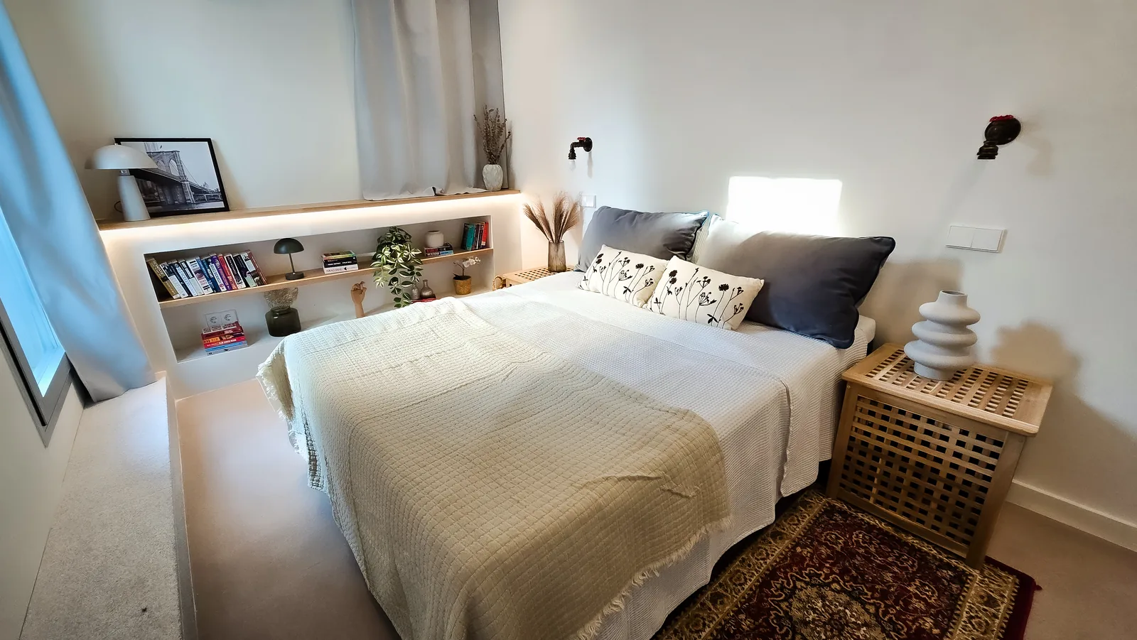 Dormitorio principal con estantería de obra iluminada con LED en la pared y cama doble