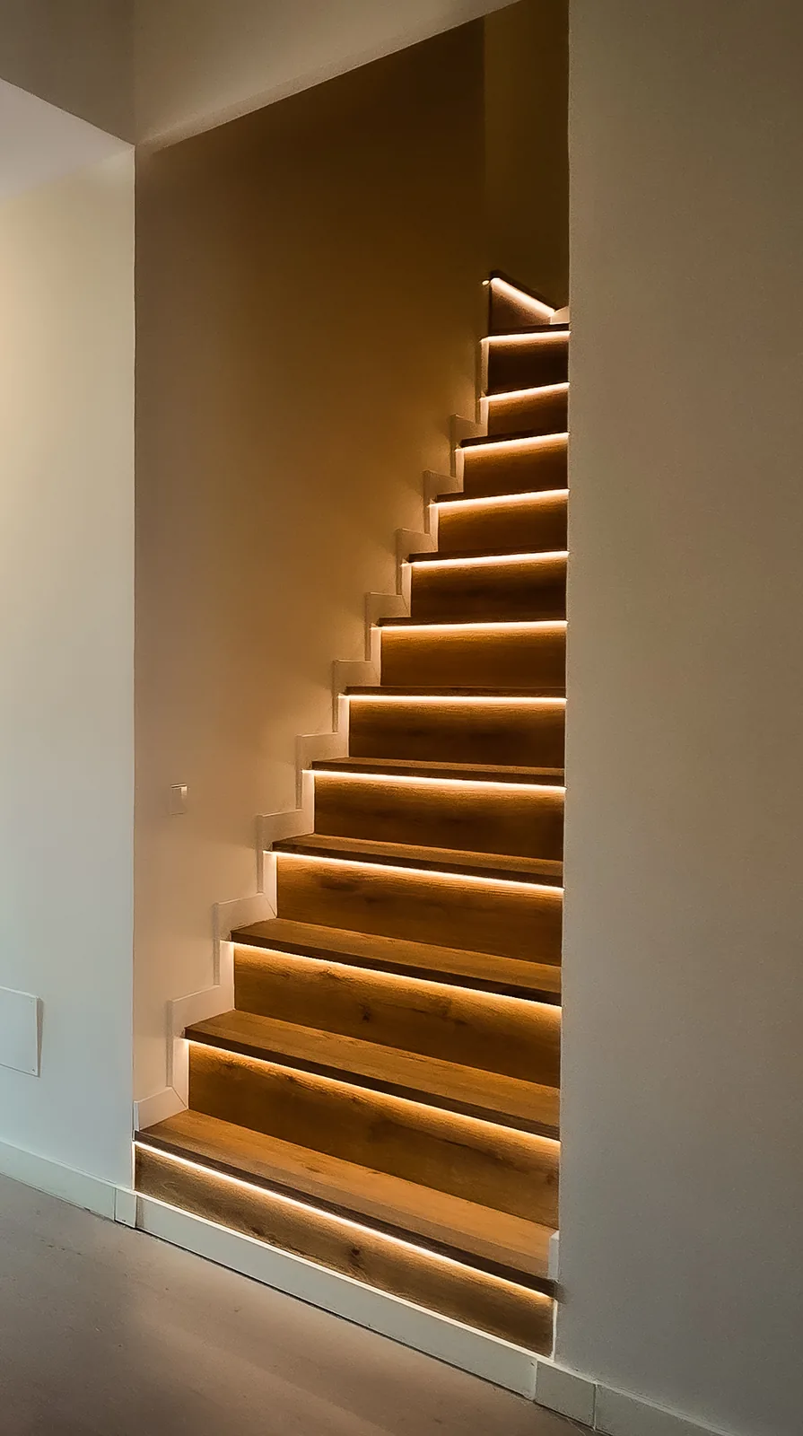 Escalera de peldaños de madera con iluminación LED que sube al dormitorio