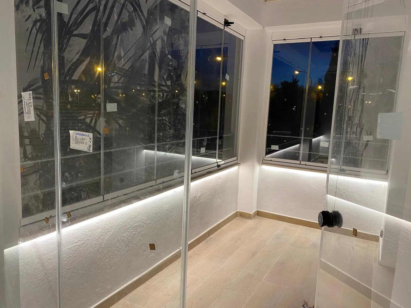Cerramiento de vidrio iluminado con LED perimetral al anochecer