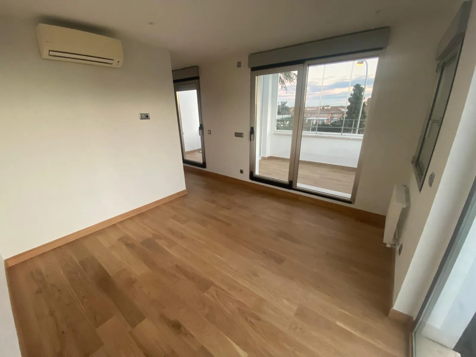 Dormitorio con tarima de roble y salida a terraza